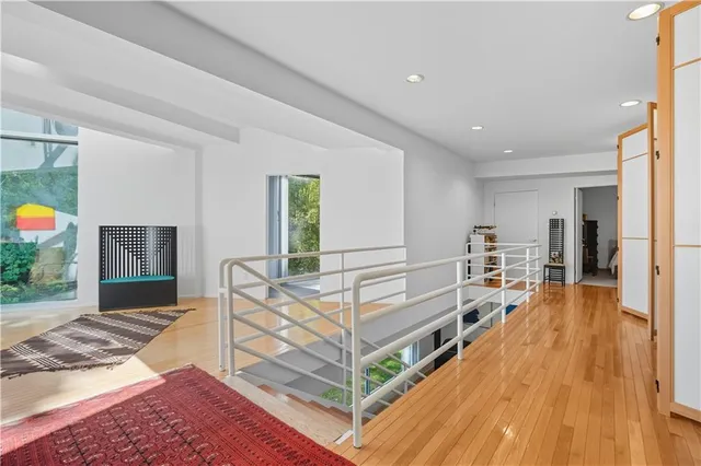 a view of a bedroom with wooden floor and windows