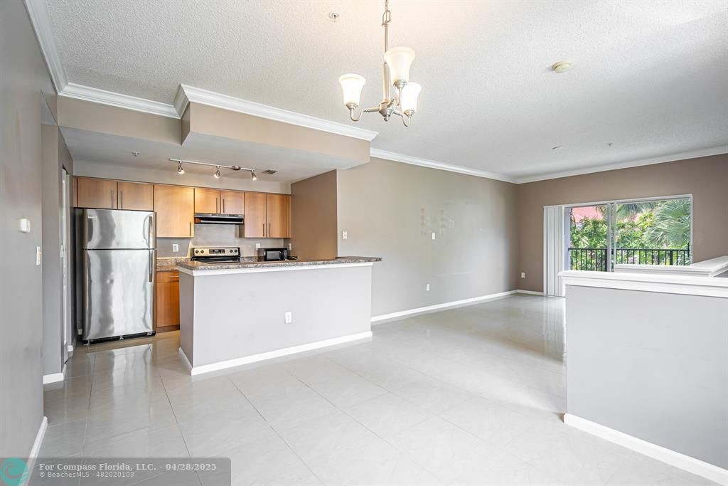 5840 West Sample Road, Unit 301 Coral Springs, FL 33067 - Photo 2 of 19 a view of kitchen with refrigerator cabinets and wooden floor