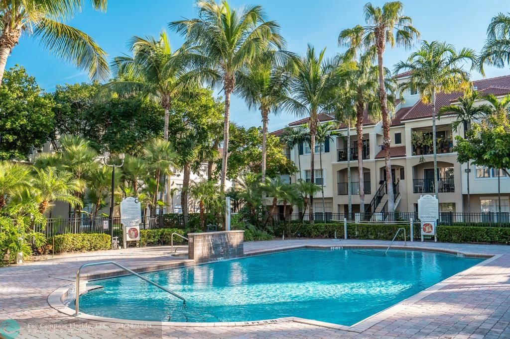 5840 West Sample Road, Unit 301 Coral Springs, FL 33067 - Photo 8 of 19 a front view of a house with swimming pool and sitting area