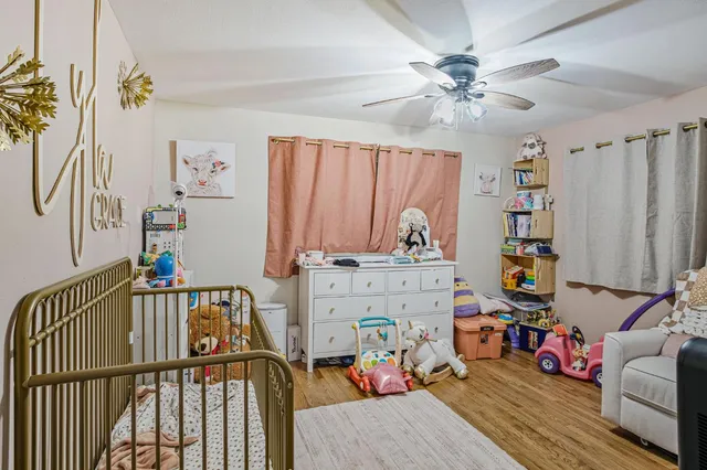 a bedroom with furniture a baby crib and a chandelier