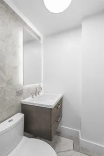 a bathroom with a toilet sink and mirror