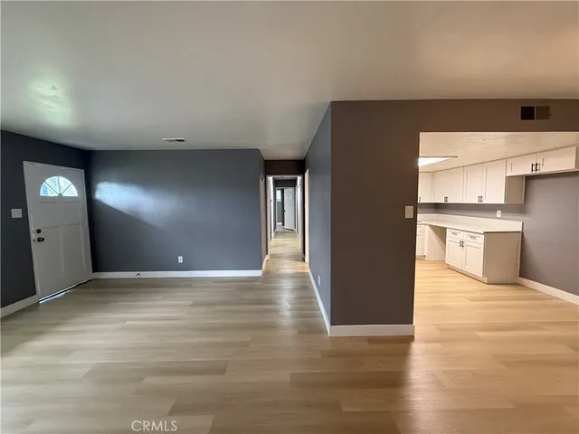 a view of a hallway with wooden floor and entryway