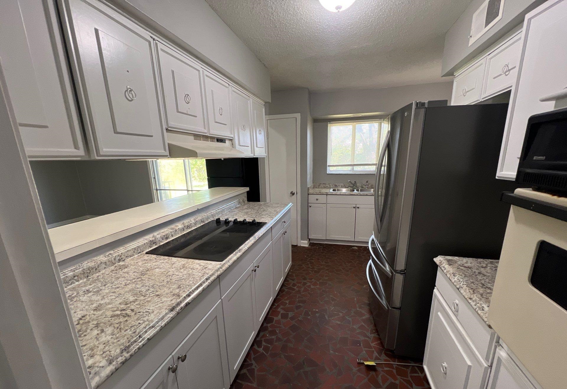 4936 Warrington Road Memphis, TN 38118 - Photo 2 of 13 a kitchen with granite countertop a refrigerator stove and sink