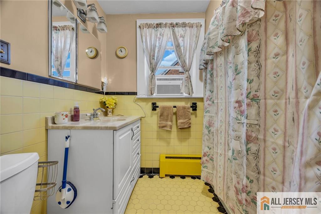 38 Simpson Avenue Edison, NJ 08817 - Photo 33 of 37 a bathroom with a sink a toilet and shower curtain