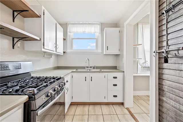 a kitchen with granite countertop white cabinets and stainless steel appliances