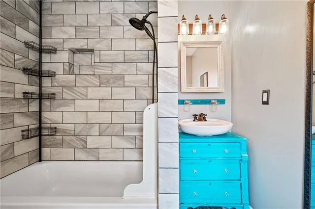 a bathroom with a bathtub sink and mirror