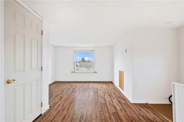 a view of a room with wooden floor closet and a window