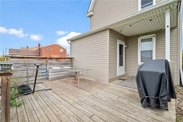 a view of a roof deck with chair and wooden floor