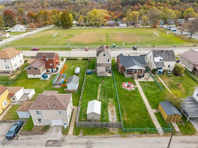 an aerial view of residential houses with outdoor space and ocean view