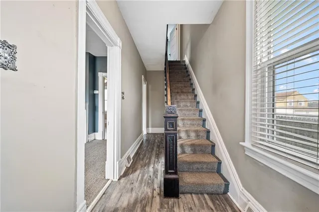 a view of a hallway with wooden floor and staircase