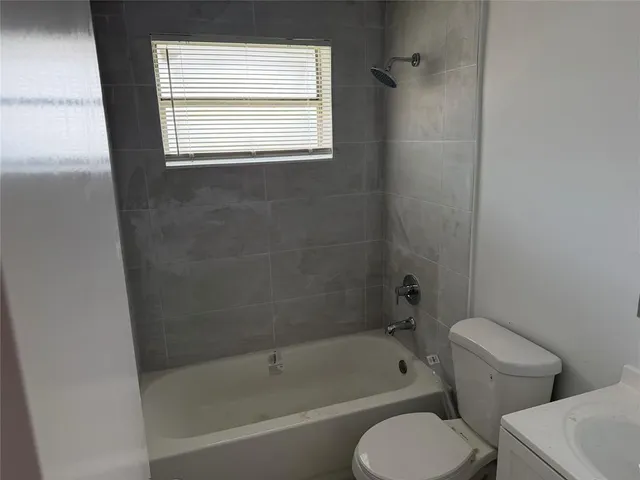 a bathroom with a toilet bathtub window and shower