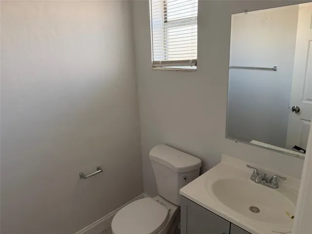 a bathroom with a sink mirror and toilet