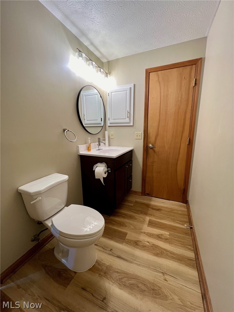 1148 Hampton Road Kent, OH 44240 - Photo 9 of 15 Bathroom with vanity, hardwood / wood-style flooring, toilet, and a textured ceiling