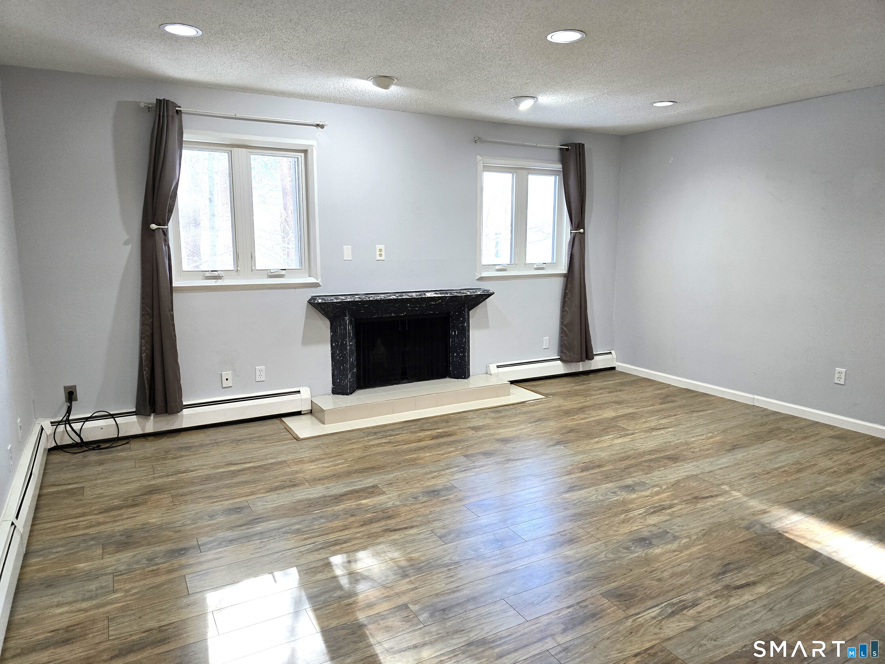 an empty room with wooden floor and window