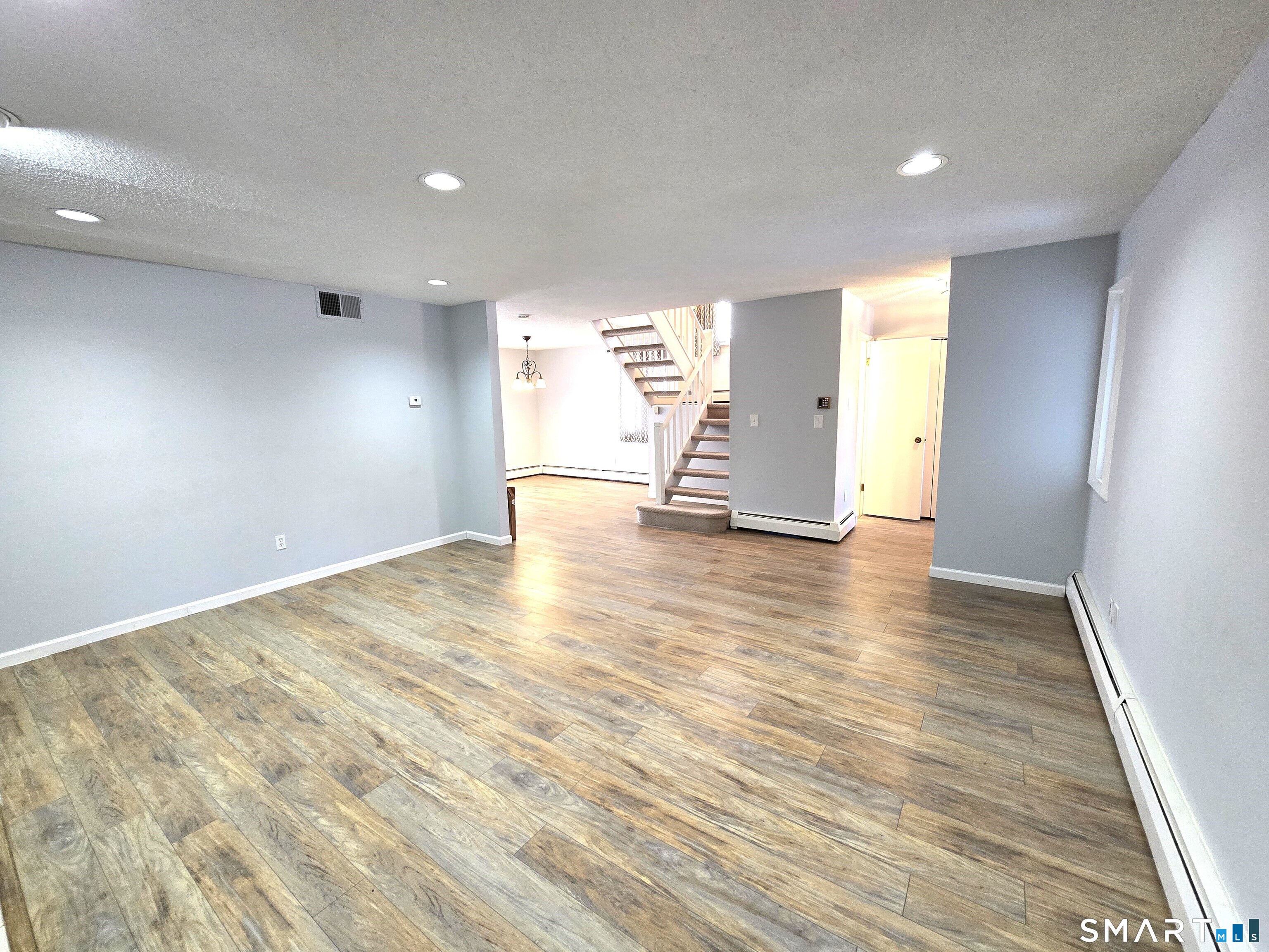 7 Staunton Court, Unit E Farmington, CT 06032 - Photo 3 of 29 an empty room with wooden floor and windows