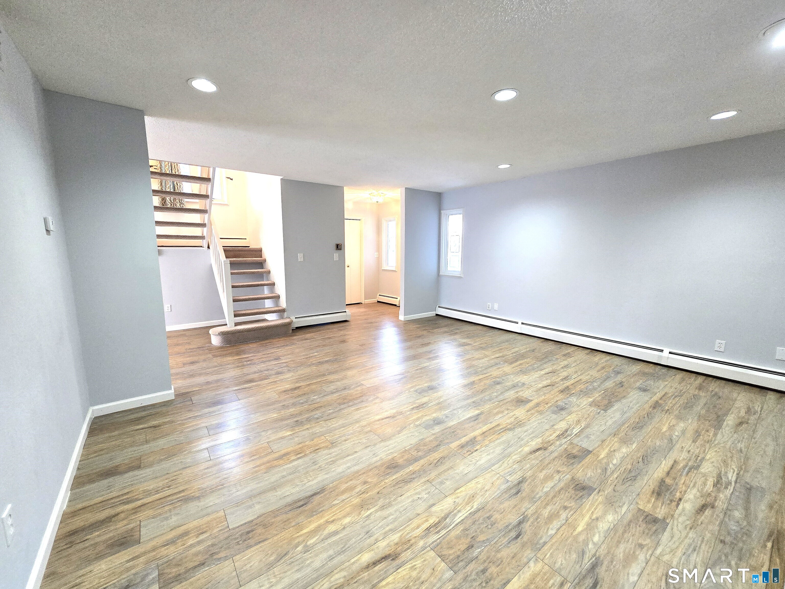 7 Staunton Court, Unit E Farmington, CT 06032 - Photo 4 of 29 an empty room with wooden floor and windows