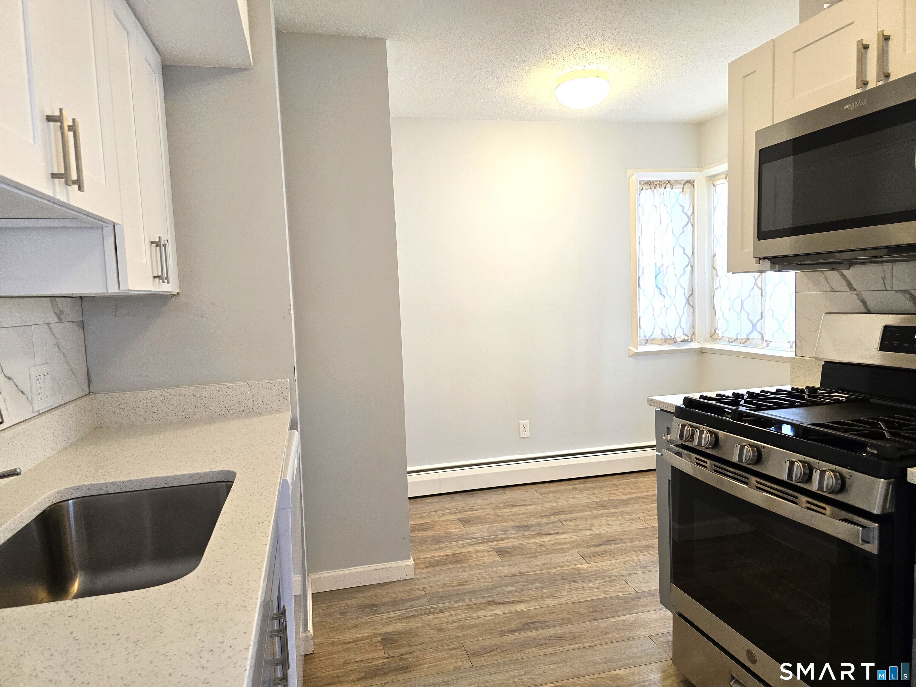 7 Staunton Court, Unit E Farmington, CT 06032 - Photo 9 of 29 a kitchen with granite countertop a stove and a sink