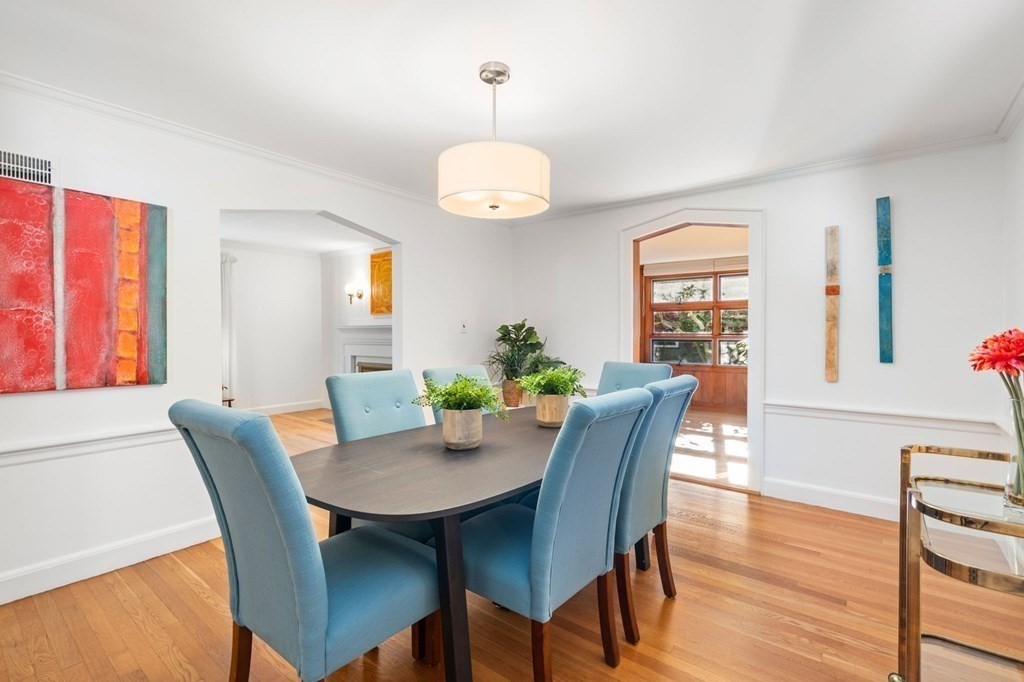49 Pierrepont Road Newton, MA 02462 - Photo 4 of 16 a dining room with wooden floor a chandelier a wooden table and chairs