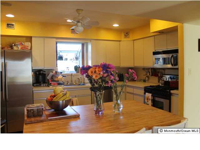 23 Pittsfield Road Howell, NJ 07731 - Photo 6 of 24 a room with kitchen island dining table chandelier and a flat screen tv