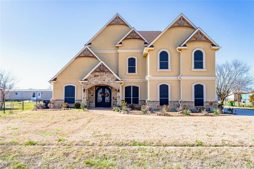 8900 Holly Road Alvarado, TX 76009 - Photo 1 of 17 Stucco exterior with stone accents, arched windows, and a prominent double entry door