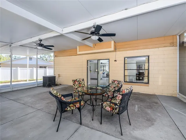 a view of a white house with a large tree and a yard
