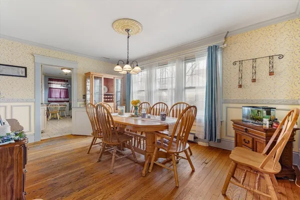 a view of a dining room with furniture a chandelier and wooden floor