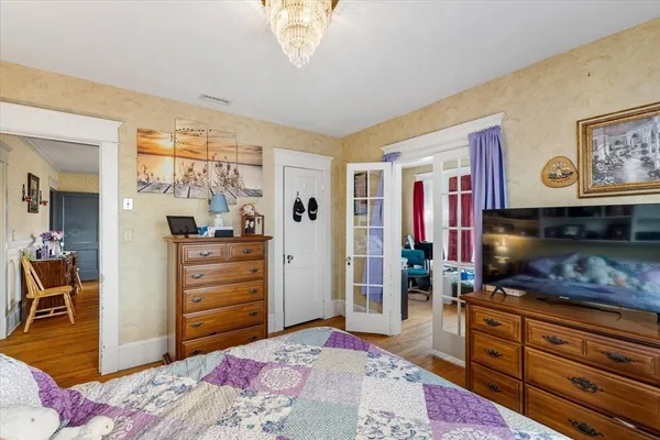 a bed room with a bed a television and dresser