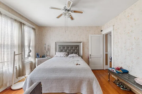 a bedroom with a bed and wooden floor