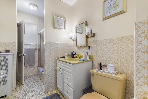 a bathroom with a granite countertop toilet and a sink