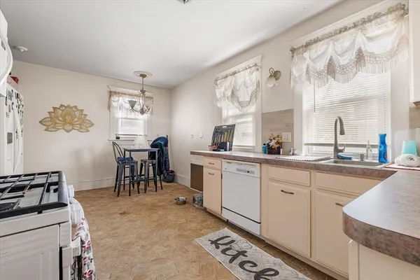 a kitchen with furniture a stove a sink and a window