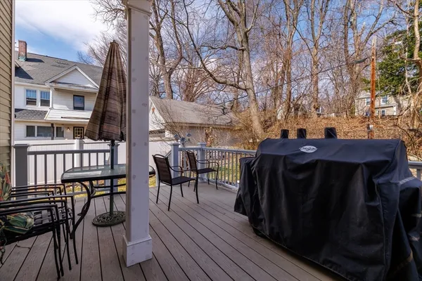 a view of a dinning table and chairs on deck with wooden floor and fence