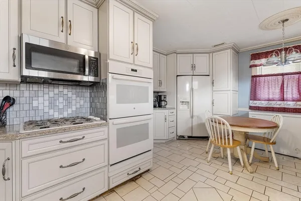 a kitchen with granite countertop cabinets appliances and a dining table