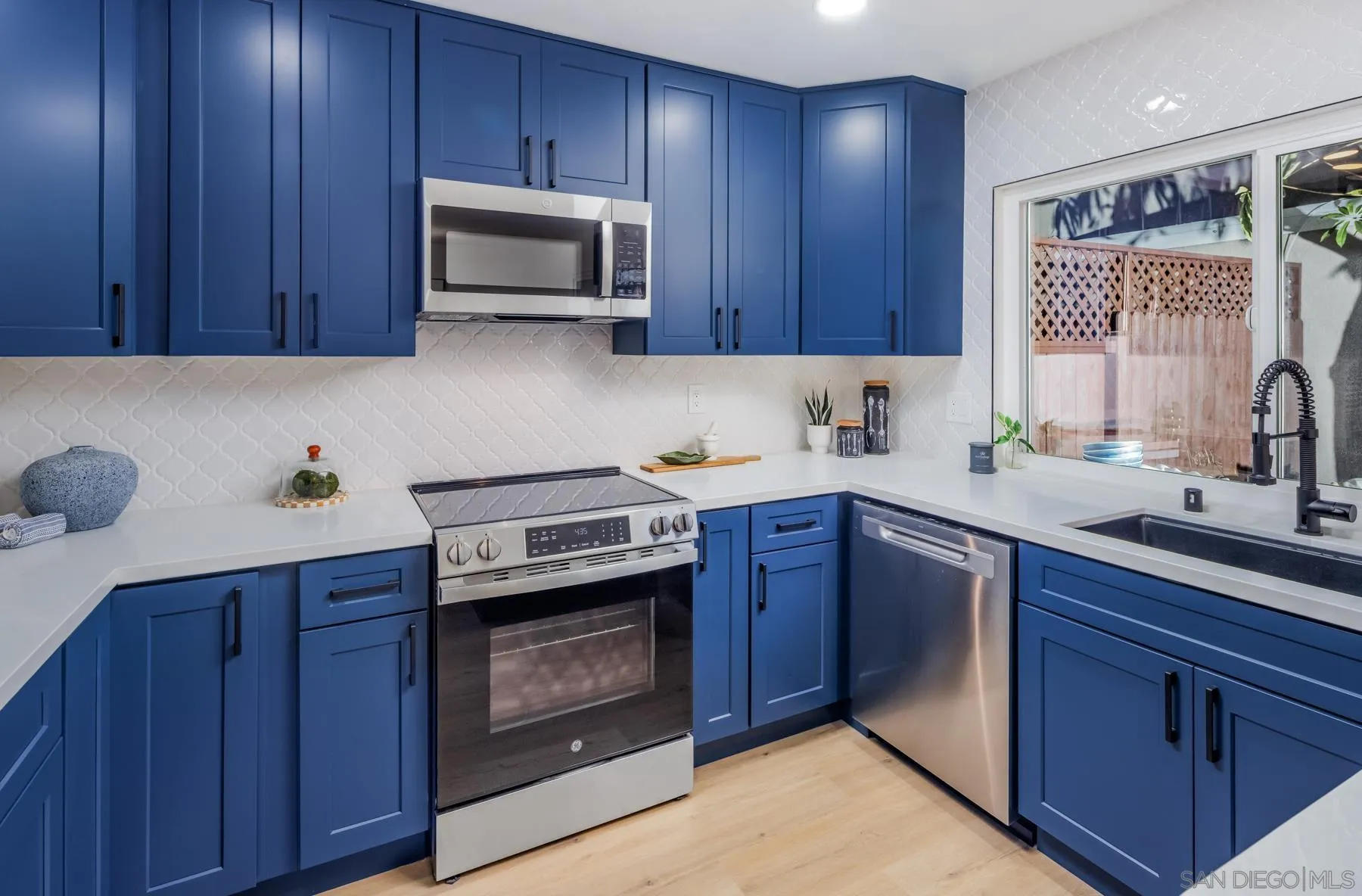 1986 Azure Way Encinitas, CA 92024 - Photo 11 of 20 a kitchen with wood cabinets a sink and a stove with wooden floor