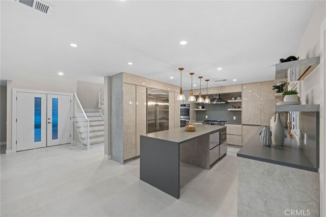 a kitchen with stainless steel appliances granite countertop a refrigerator and a sink