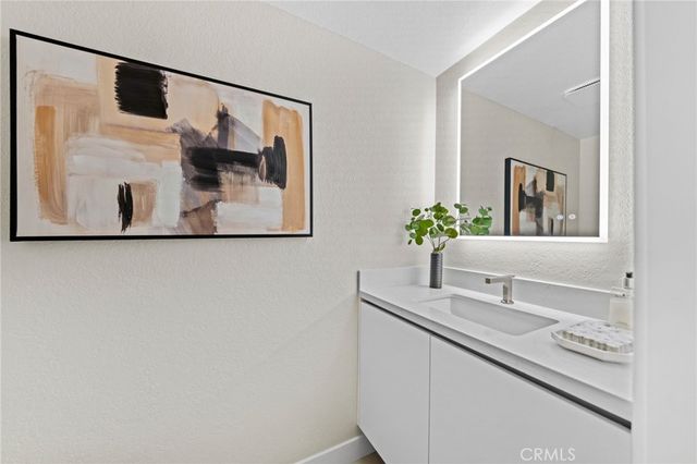 a view of staircase with lots of frames and white walls