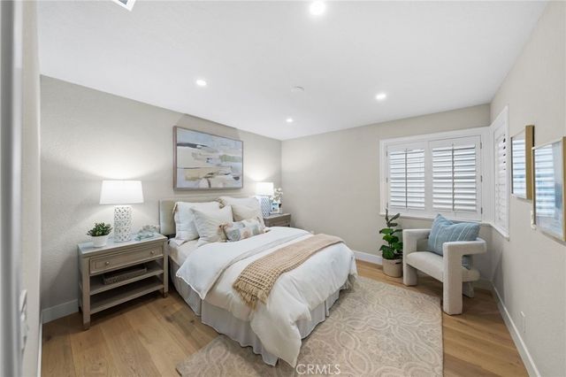 a view of a hallway with bathroom and wooden floor
