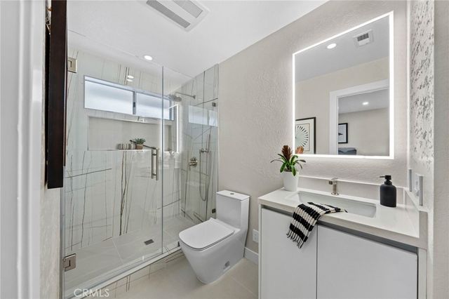 a bathroom with a bathtub mirror and a sink