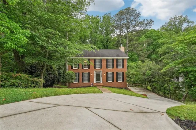 a front view of a house with a yard and potted plants