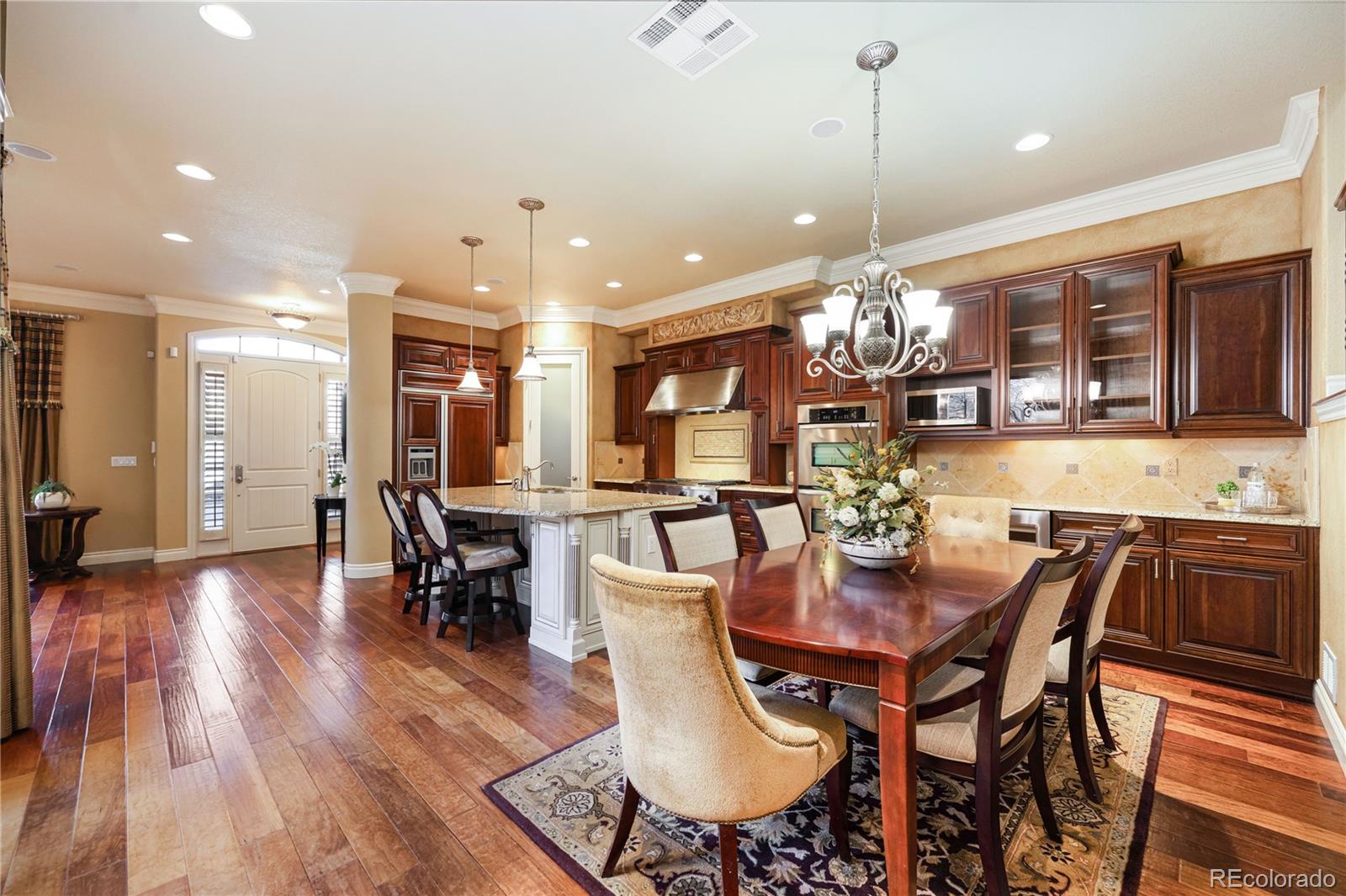9132 Mornington Way Lone Tree, CO 80124 - Photo 13 of 44 a view of a dining room and livingroom with furniture wooden floor a chandelier