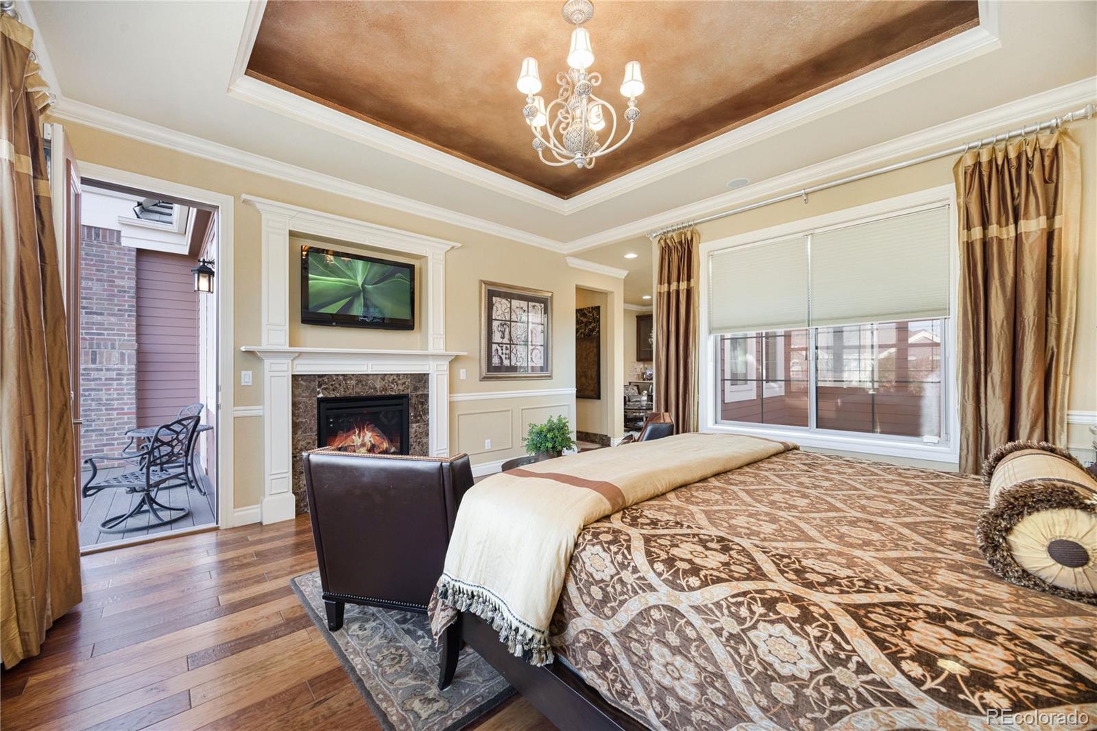 9132 Mornington Way Lone Tree, CO 80124 - Photo 22 of 44 a spacious bedroom with a large bed and a fireplace