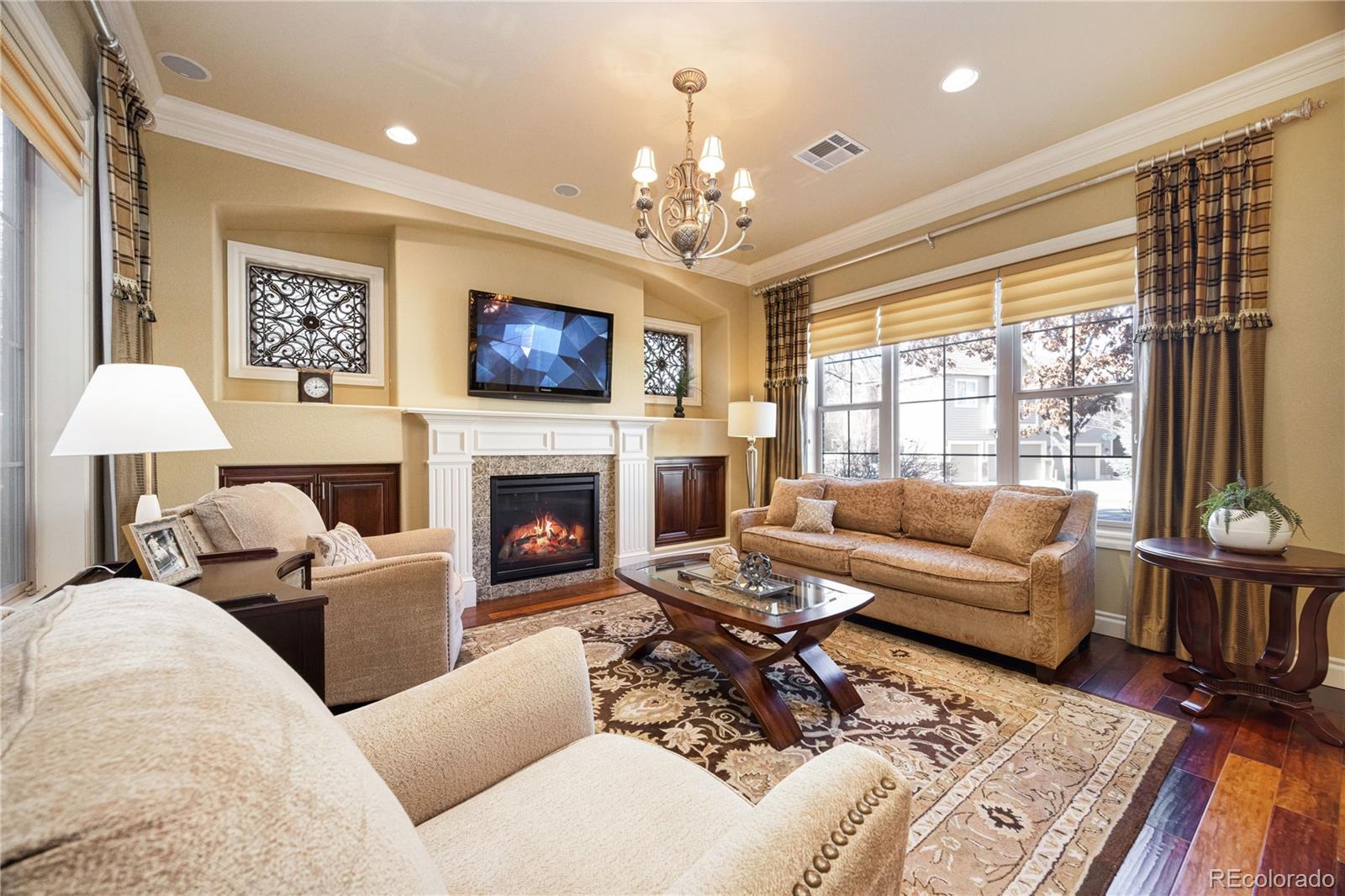 9132 Mornington Way Lone Tree, CO 80124 - Photo 4 of 44 a living room with furniture a fireplace and a flat screen tv