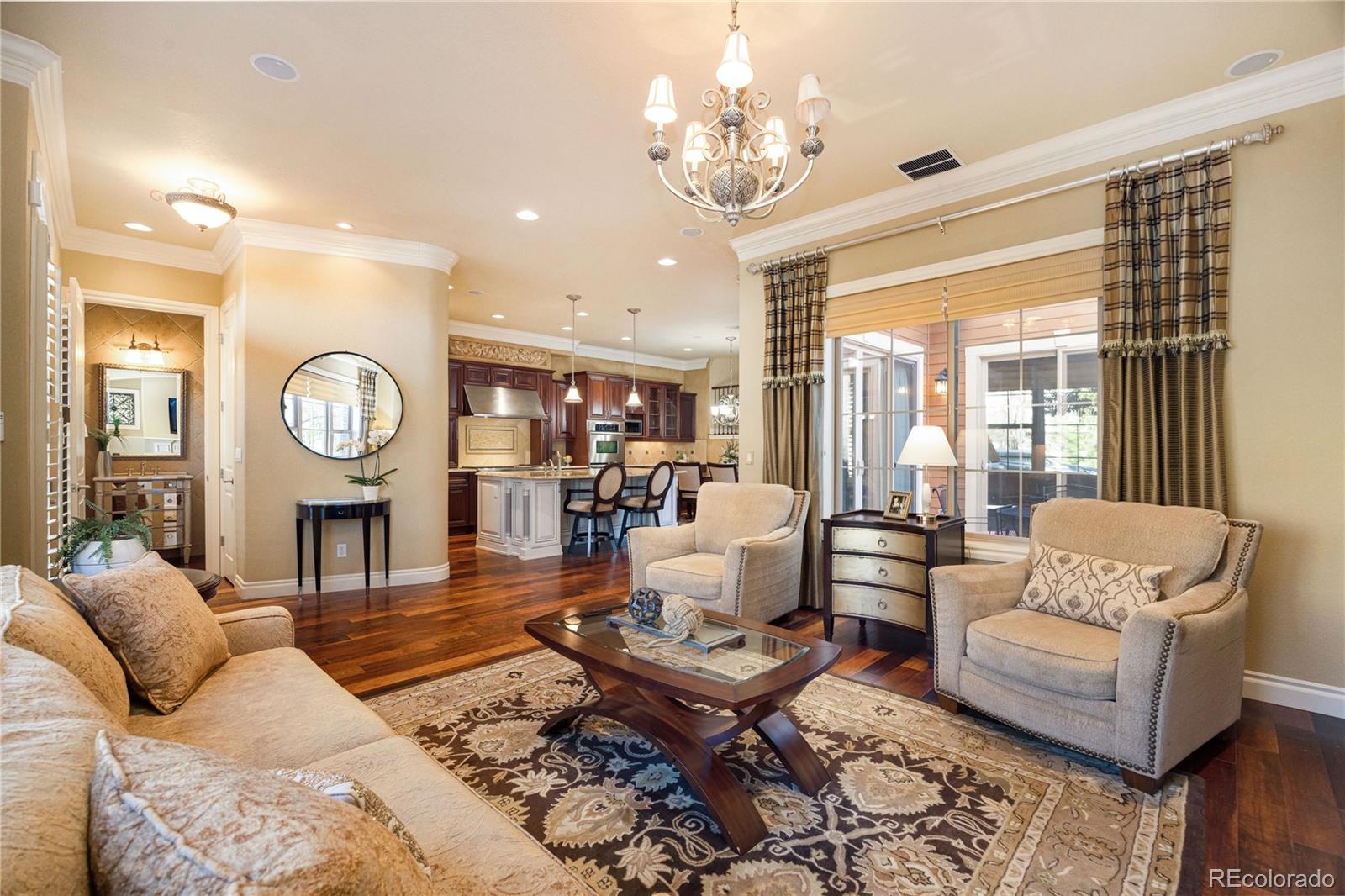 9132 Mornington Way Lone Tree, CO 80124 - Photo 6 of 44 a living room with fireplace furniture and a chandelier