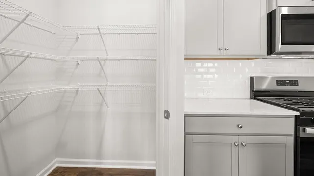 a view of a kitchen with white cabinets