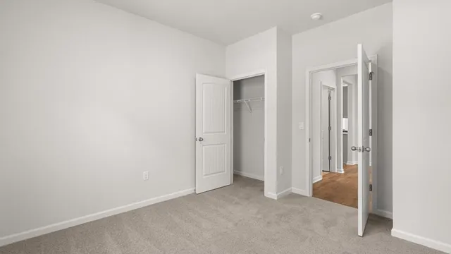 an empty room with closet and a bathroom