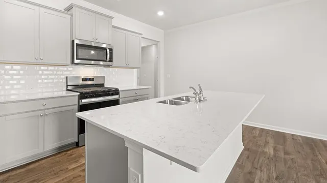 a kitchen with a sink a stove and microwave