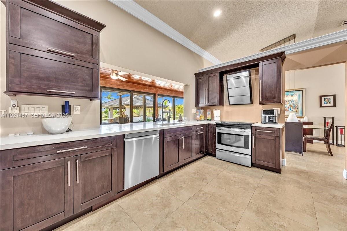 3801 Southwest 141st Avenue Miramar, FL 33027 - Photo 38 of 99 a large kitchen with stainless steel appliances granite countertop a stove a sink and a microwave