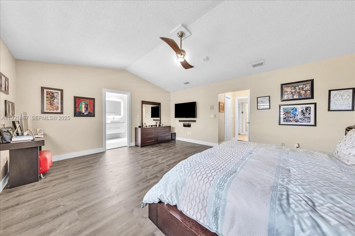 3801 Southwest 141st Avenue Miramar, FL 33027 - Photo 49 of 99 a spacious bedroom with a bed and a flat screen tv