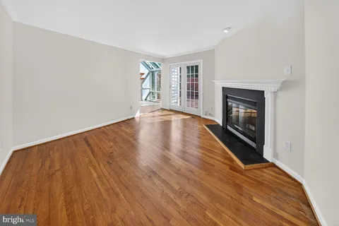 a view of empty room with wooden floor and fireplace