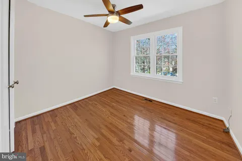 an empty room with a window and a ceiling fan