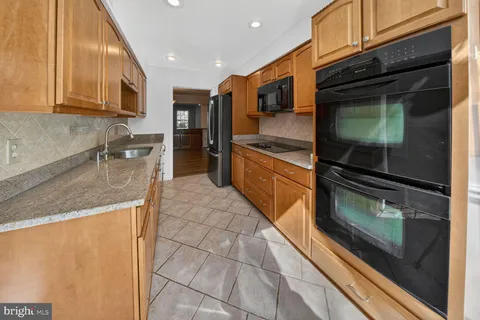 a kitchen with stainless steel appliances granite countertop a stove a microwave and a sink